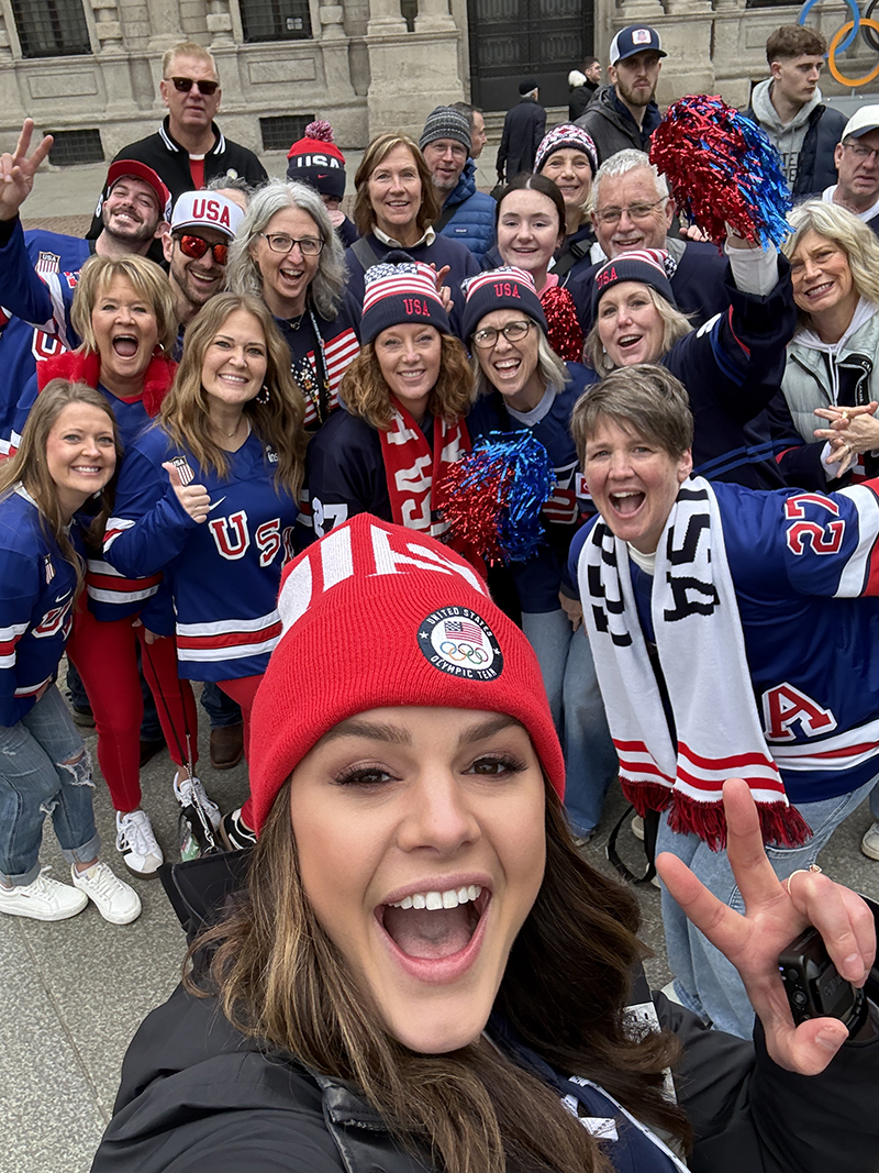Alicia Lewis poses for a photo with U.S. Womens Hockey supporters at the 2026 Winter Olympics