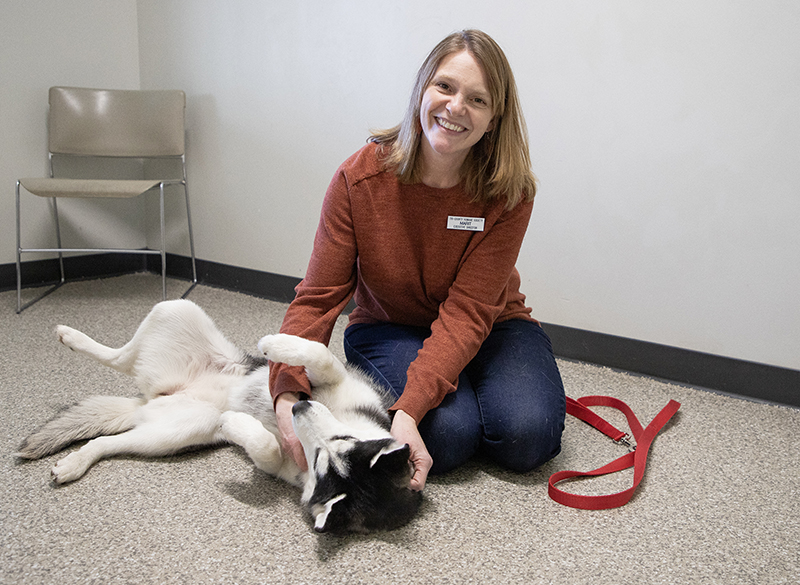 Marit Ortega playing with a dog a the the Tri-County Humane Society