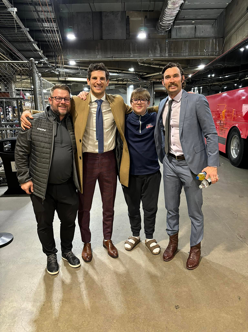 Matt Chapman posing with his son and two former Huskies Hockey players.